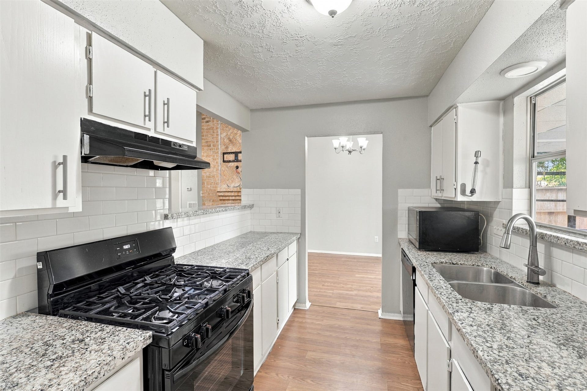 3011 Helmsley Drive, Pearland, TX 77584 An alternate kitchen view highlights the gas range, granite work surfaces, and upper and lower cabinet storage.