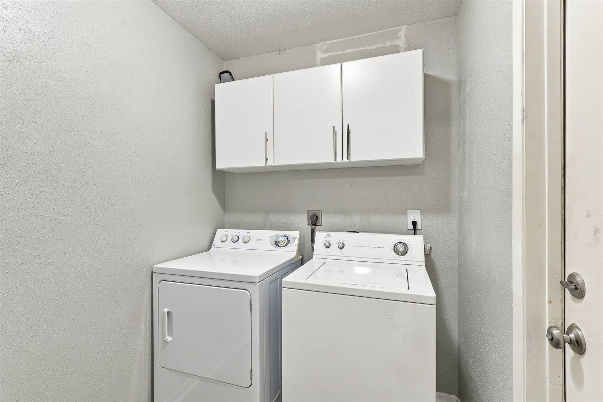 3011 Helmsley Drive, Pearland, TX 77584 Dedicated laundry area includes overhead cabinetry to keep laundry supplies organized and within reach.