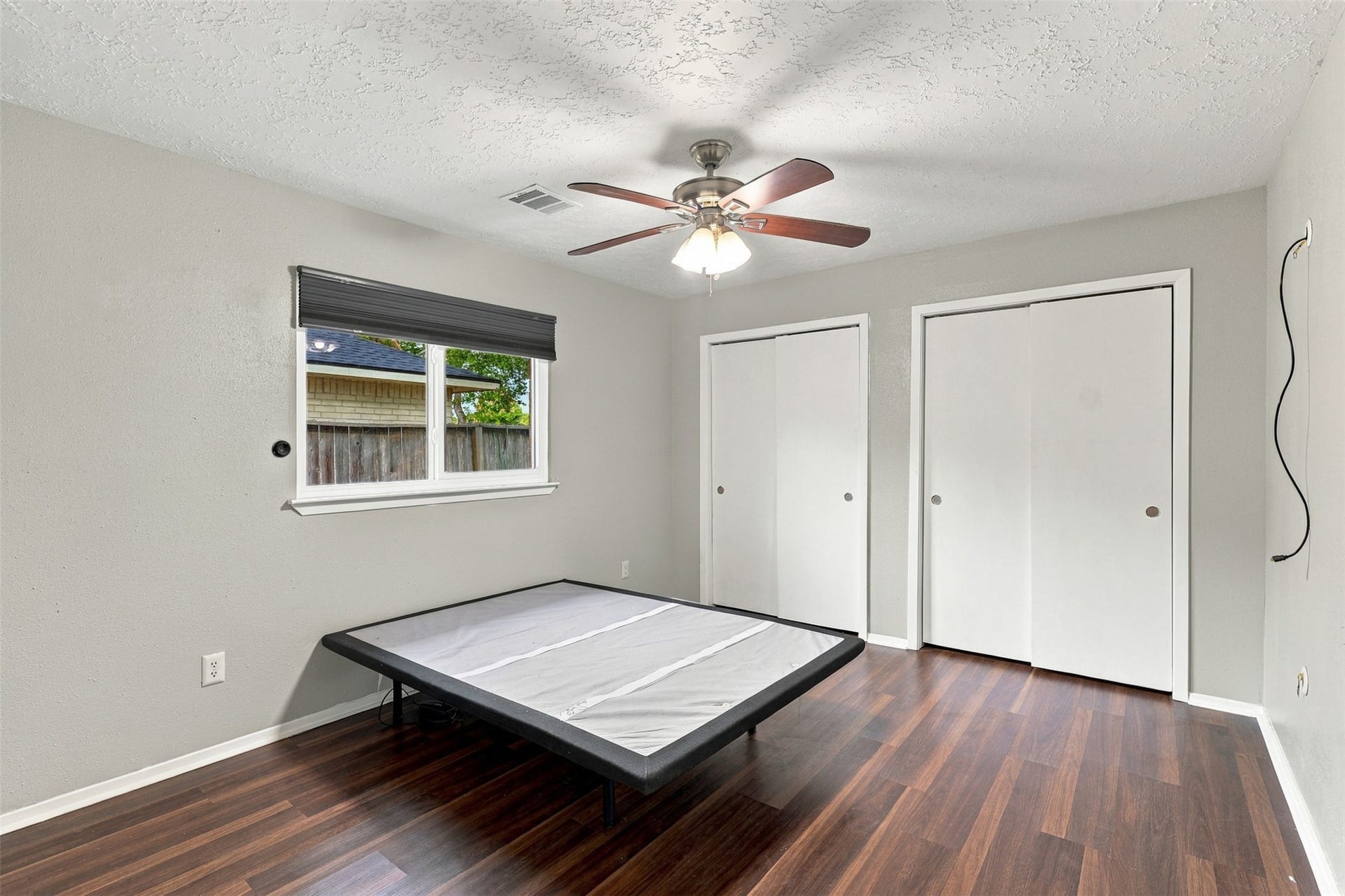 3011 Helmsley Drive, Pearland, TX 77584 Primary bedroom features wood-look flooring, a ceiling fan, natural light, and double closet doors.