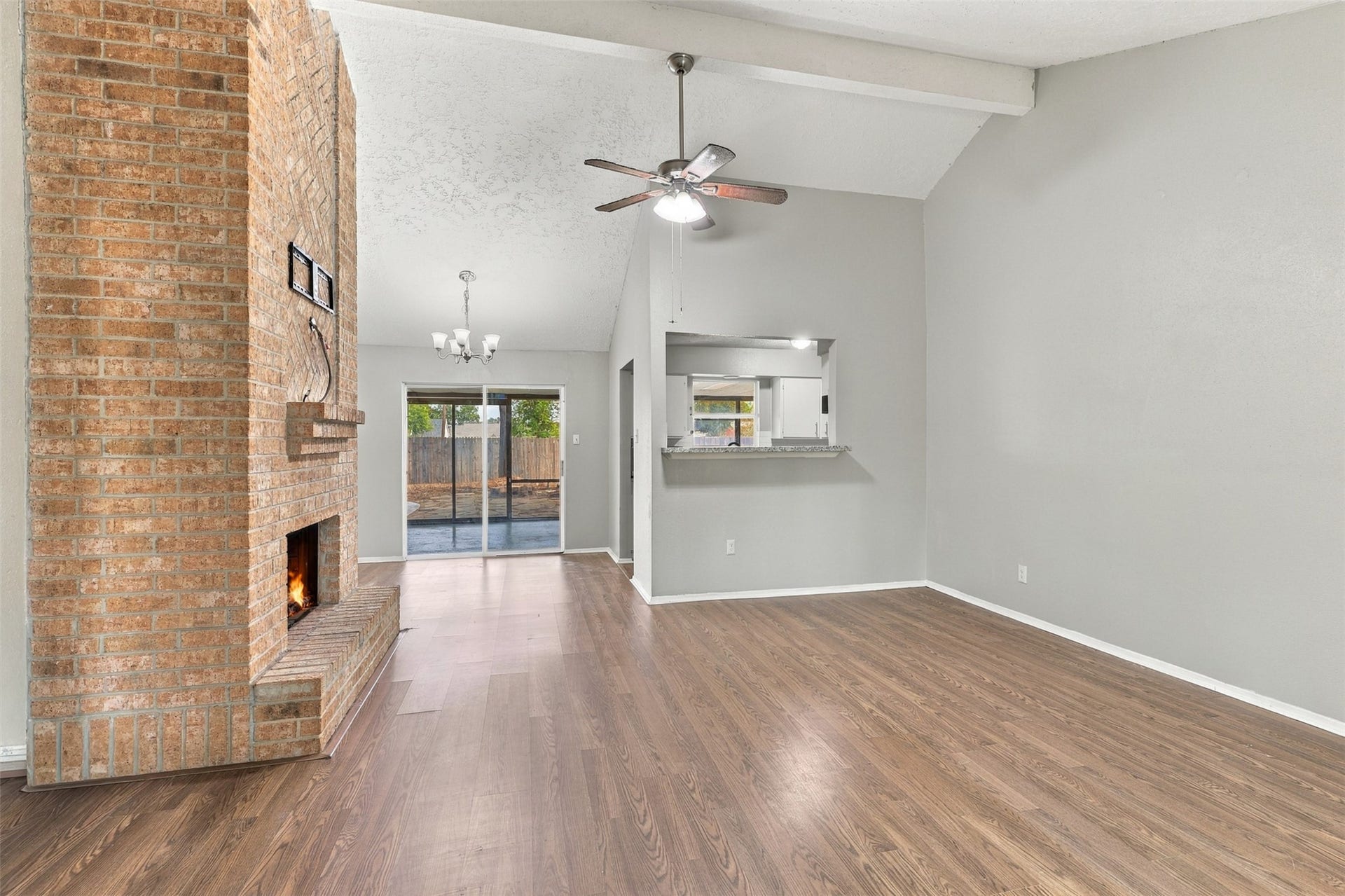 3011 Helmsley Drive, Pearland, TX 77584 Living room features wood-look flooring, a vaulted ceiling, and an open connection to the kitchen.