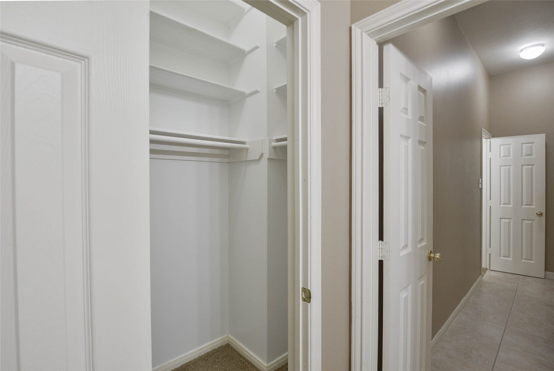 7023 Timber Edge Lane Lane, Humble, TX 77346 Spacious walk-in closet with ample shelving and hanging space, conveniently located off a well-lit hallway.