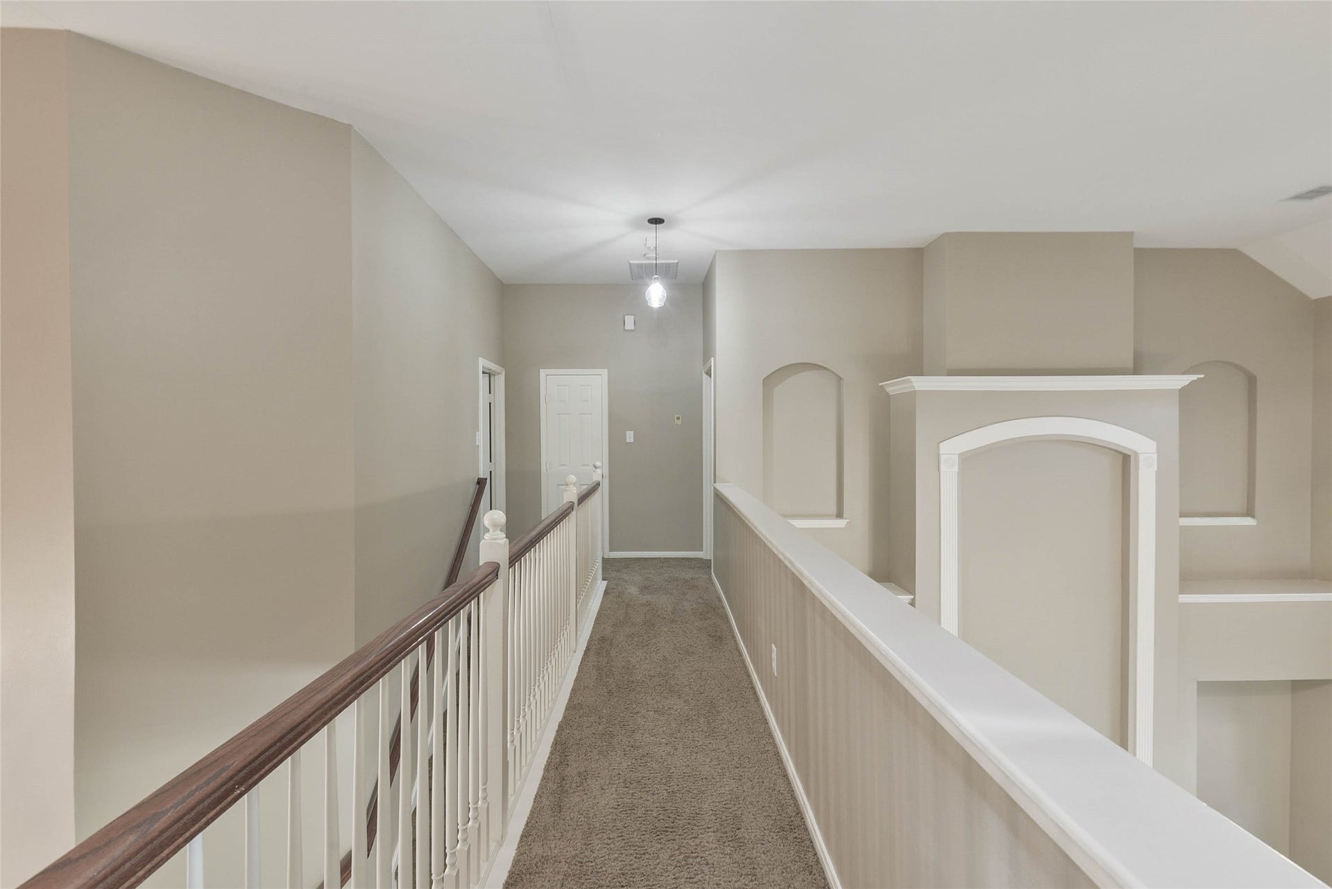 7023 Timber Edge Lane Lane, Humble, TX 77346 Elegant upstairs hallway with neutral tones, featuring a plush carpet and stylish architectural details.