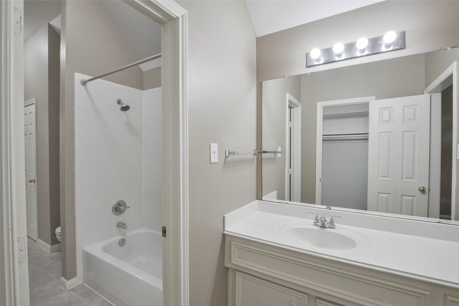 7023 Timber Edge Lane Lane, Humble, TX 77346 Secondary bathroom featuring a large vanity, bright lighting, and a clean bathtub with a shower.