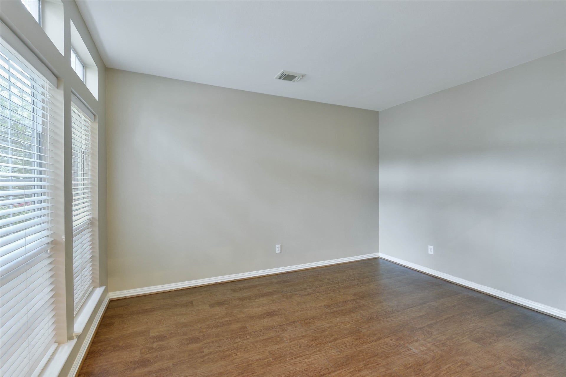 7023 Timber Edge Lane Lane, Humble, TX 77346 Bright room with large windows, sleek hardwood floors, and neutral walls, perfect for a cozy living space or home office.