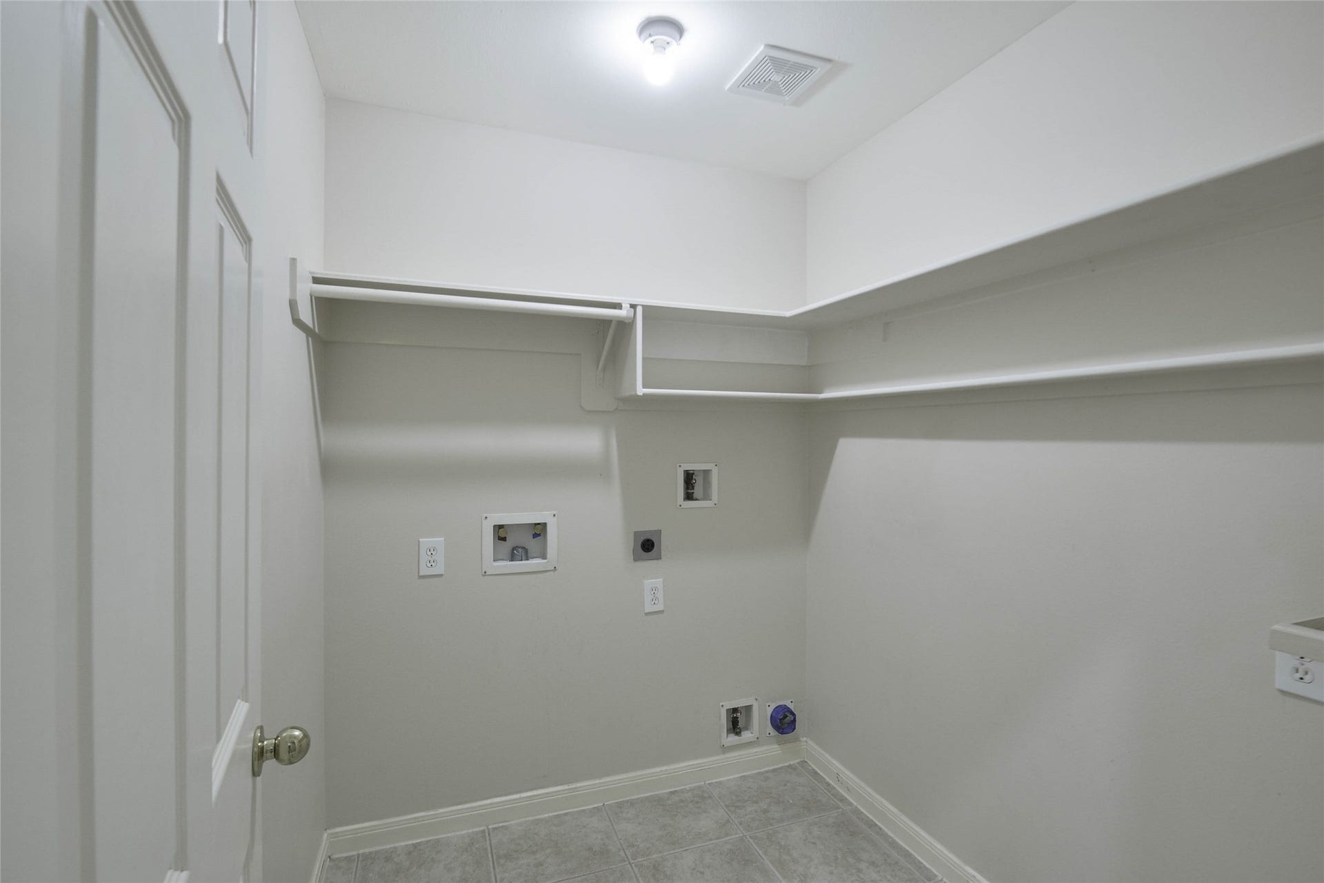 7023 Timber Edge Lane Lane, Humble, TX 77346 Laundry room featuring ample shelving and hookups for washer and dryer.
