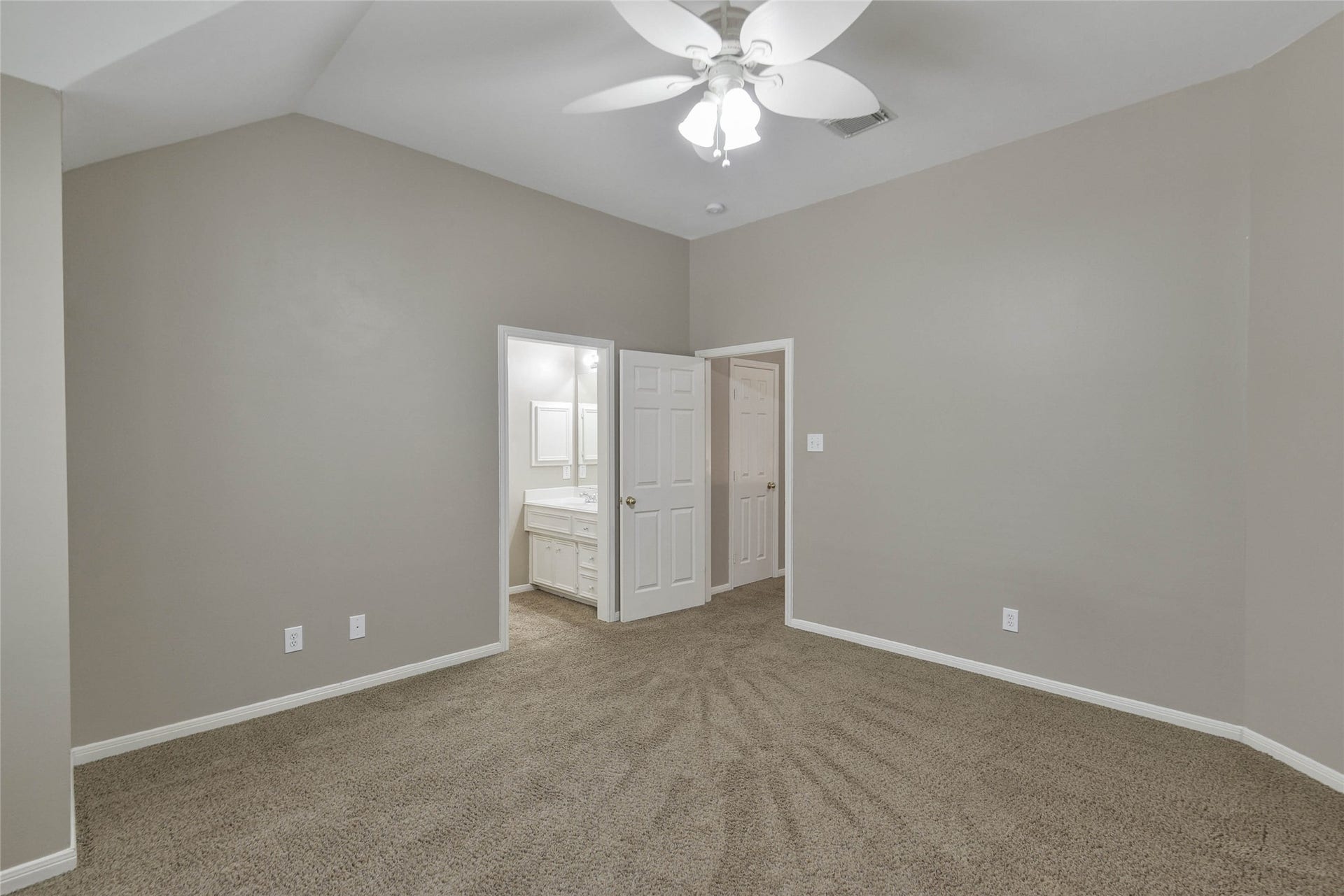 7023 Timber Edge Lane Lane, Humble, TX 77346 Secondary bedroom with neutral tones, plush carpeting, and a ceiling fan, leading to an en-suite bathroom for added convenience.