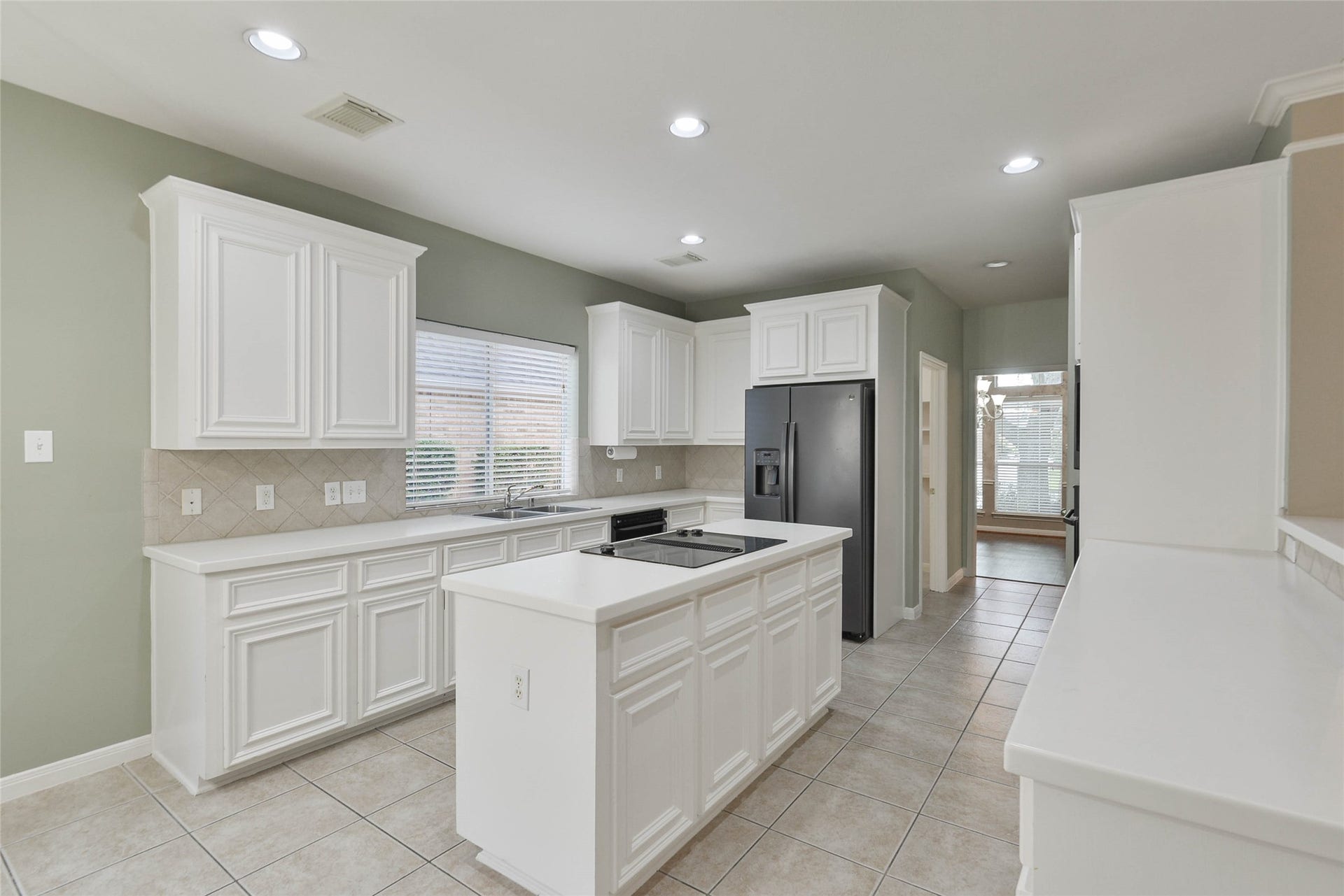 7023 Timber Edge Lane Lane, Humble, TX 77346 Kitchen featuring sleek white cabinetry, modern appliances, and a central island perfect for meal prep and gatherings.