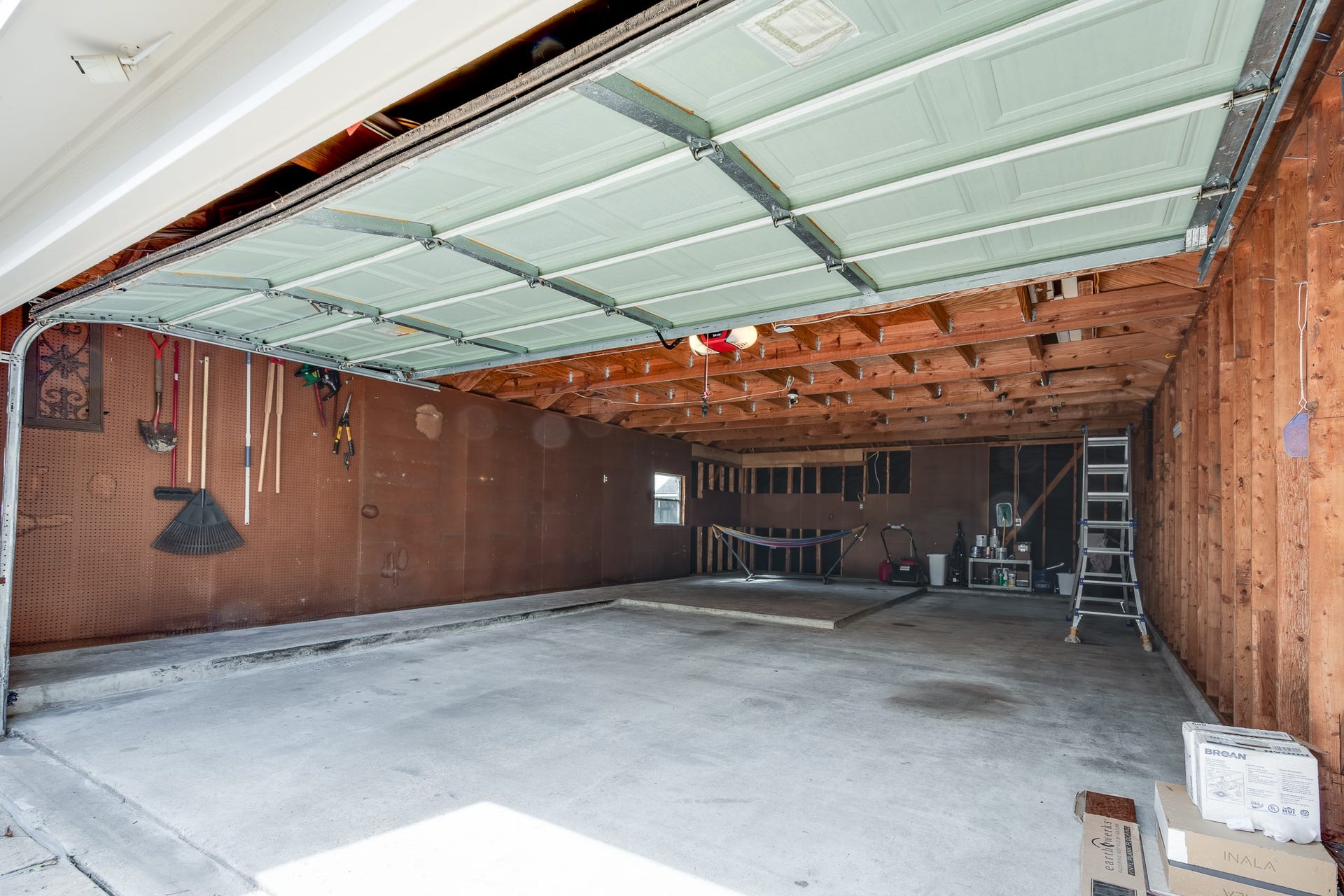 7023 Timber Edge Lane Lane, Humble, TX 77346 Spacious garage with ample storage, featuring pegboard walls for organization and exposed beams for added character.