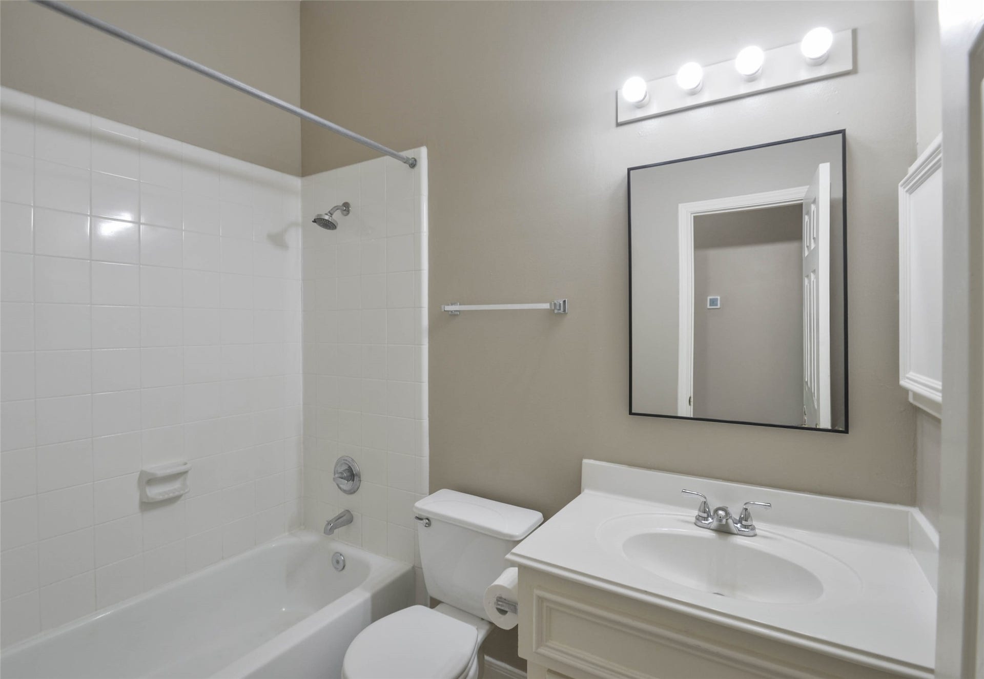7023 Timber Edge Lane Lane, Humble, TX 77346 Secondary bathroom featuring a classic white tile shower-tub combo, a sleek vanity with ample counter space, and modern lighting above a large mirror.