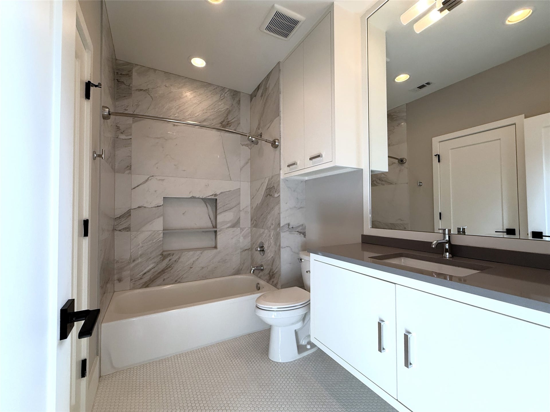 Tub/shower combo with built-in space for shampoo, etc. Picture taken from the living room entrance.