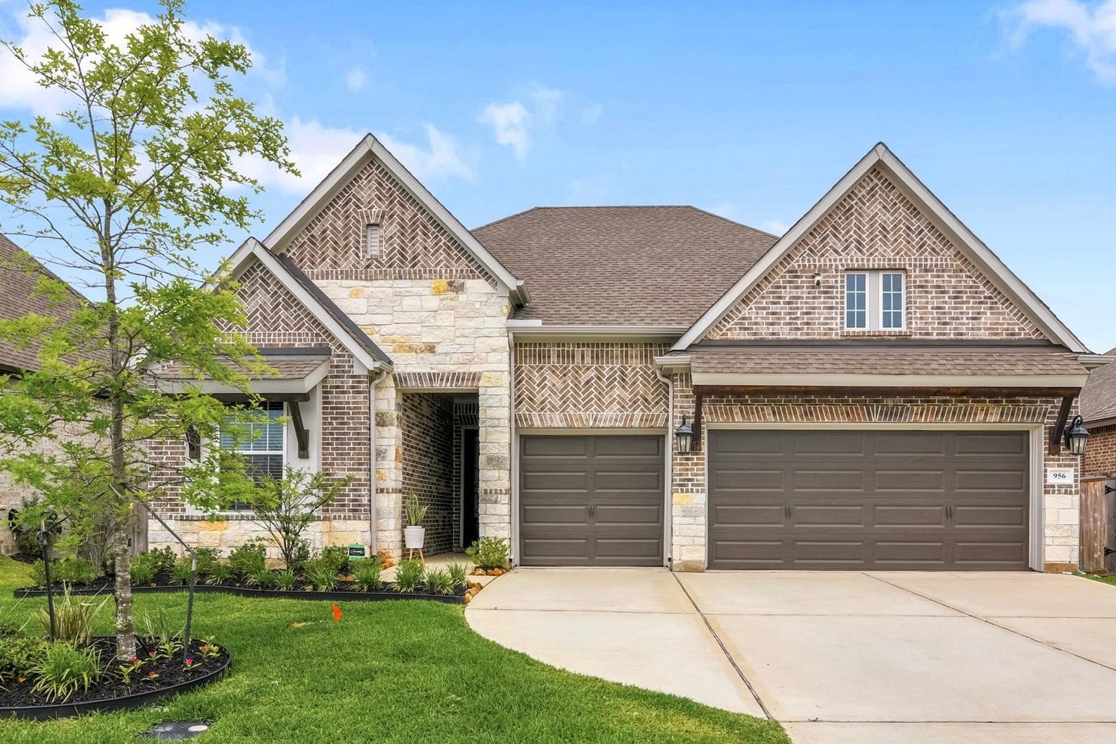 Modern brick home with three-car garage. Spacious driveway and neatly landscaped front yard offering great curb appeal.