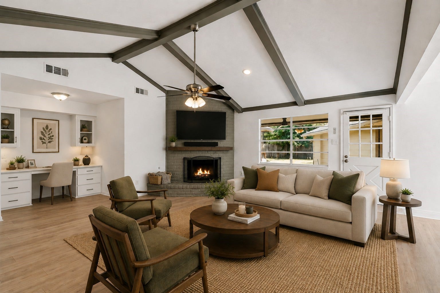 11810 Rowood Drive, Houston, TX 77070 Virtually Staged: This spacious family room features a vaulted ceiling with exposed beams, a brick fireplace, and warm wood-look flooring. The open layout offers plenty of room for comfortable seating, while the built-in study nook provides a convenient dedicated workspace.