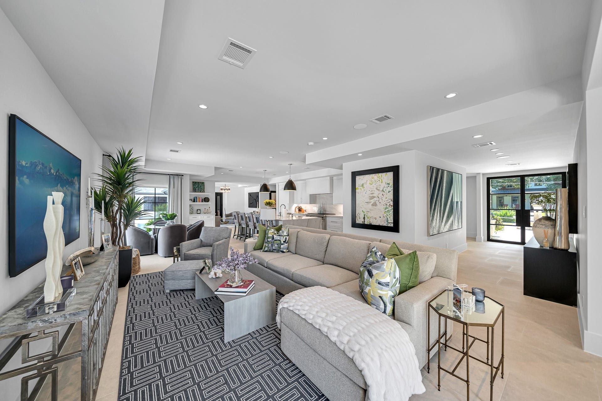 Spacious and thoughtfully designed open-concept living area with modern decor, ample natural light, and seamless flow into the dining and kitchen spaces.
