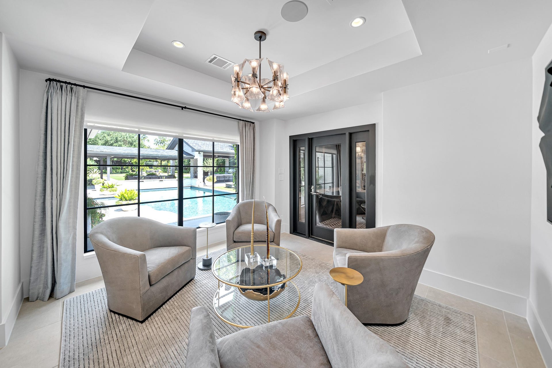 Seating area with floor-to-ceiling windows, surround sound speakers, and decorative lighting.