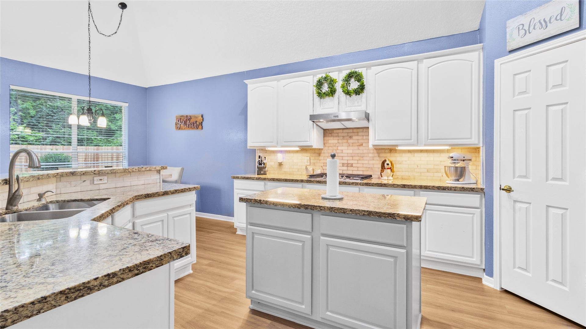 20214 Powerscourt Drive, Humble, TX 77346 Bright and inviting, the kitchen area features a cozy dining space with soft blue accents and beautiful views of the outdoor greenery.