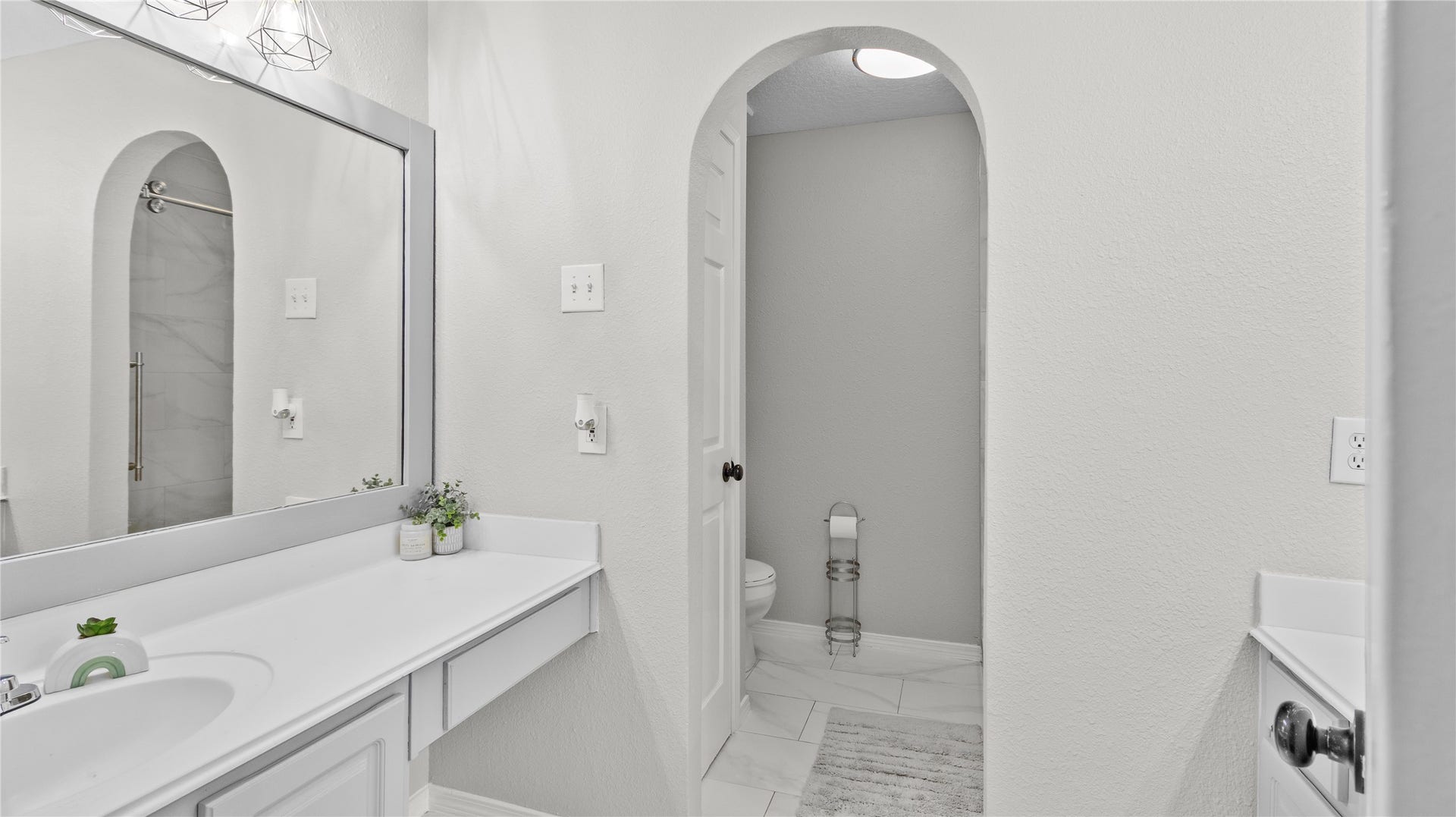 20214 Powerscourt Drive, Humble, TX 77346 Bright and modern upstairs bathroom featuring a large vanity with ample storage, a framed mirror, and a sleek glass-enclosed shower.