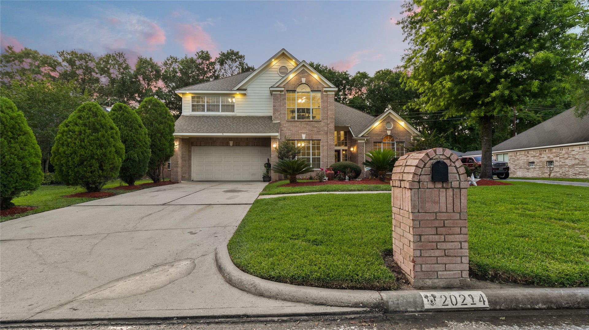 20214 Powerscourt Drive, Humble, TX 77346 Subtle evening lighting is strategically placed to accentuate the brick facade, ensuring the home remains inviting long after sunset