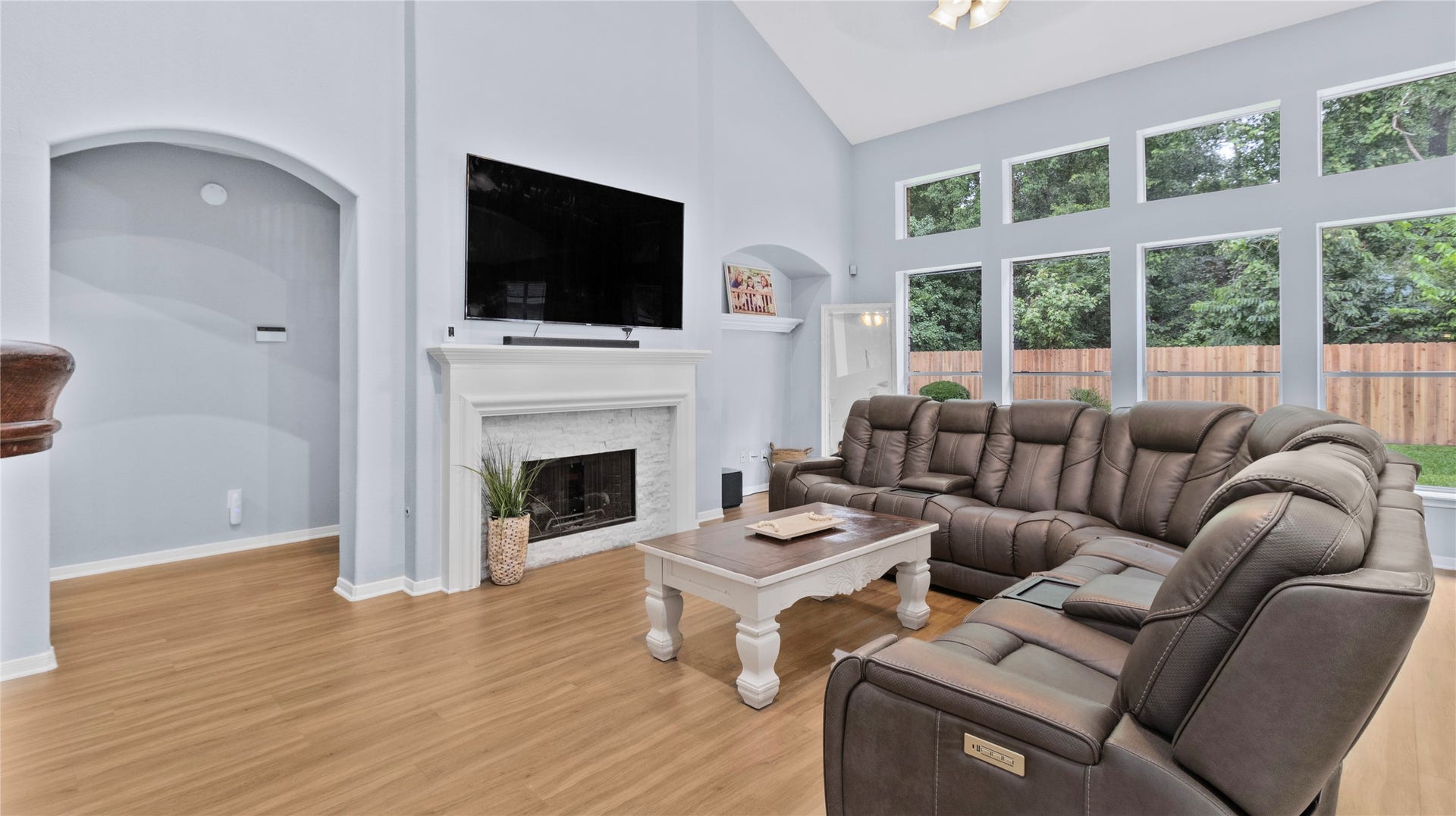 20214 Powerscourt Drive, Humble, TX 77346 Relax in the light-filled family room, centered around a cozy fireplace with views of the lush, green backyard through oversized windows.