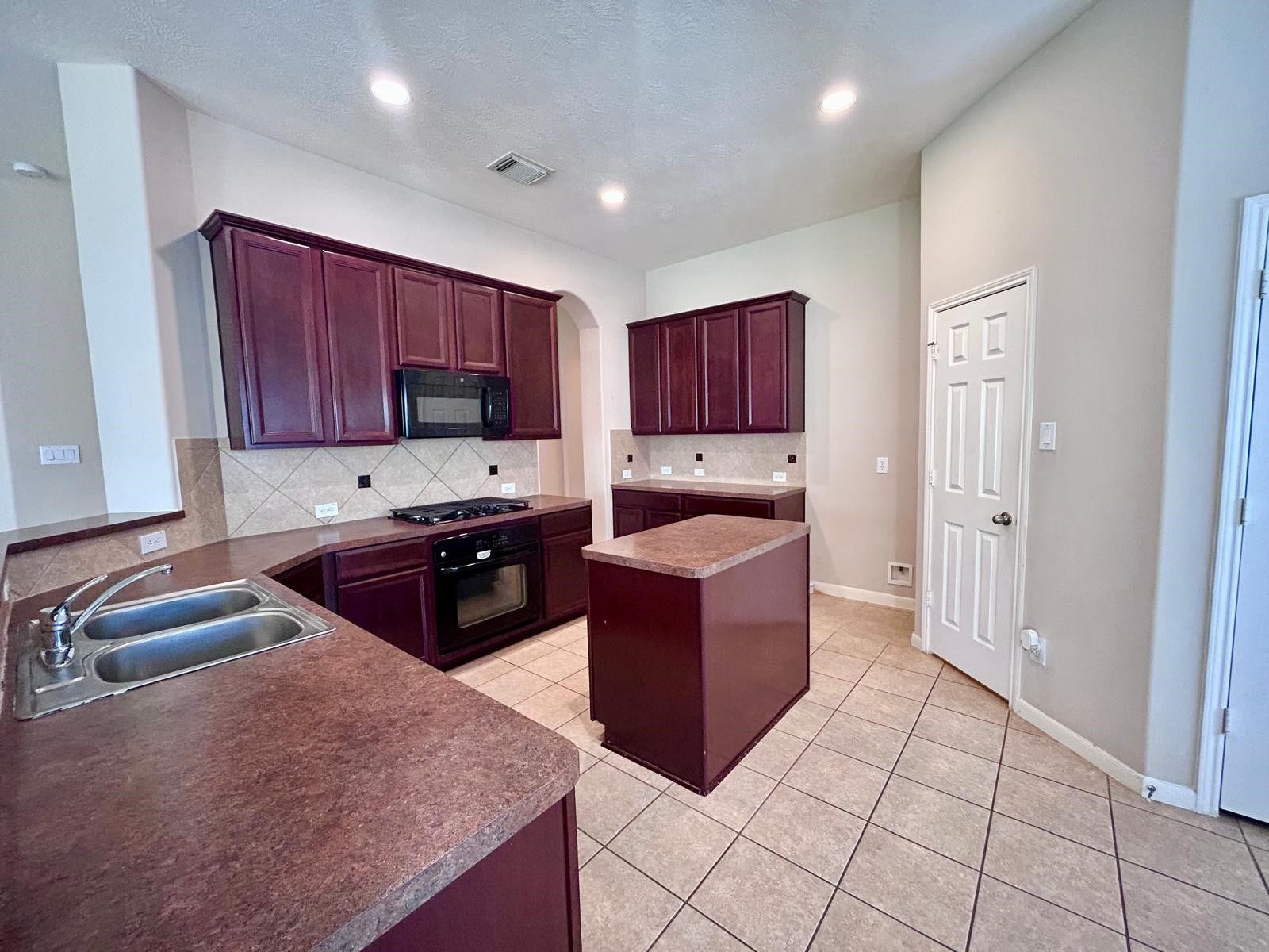 25918 Silver Timbers Lane, Katy, TX 77494 Spacious kitchen featuring rich wood cabinetry, modern appliances, and a central island, perfect for culinary enthusiasts.
