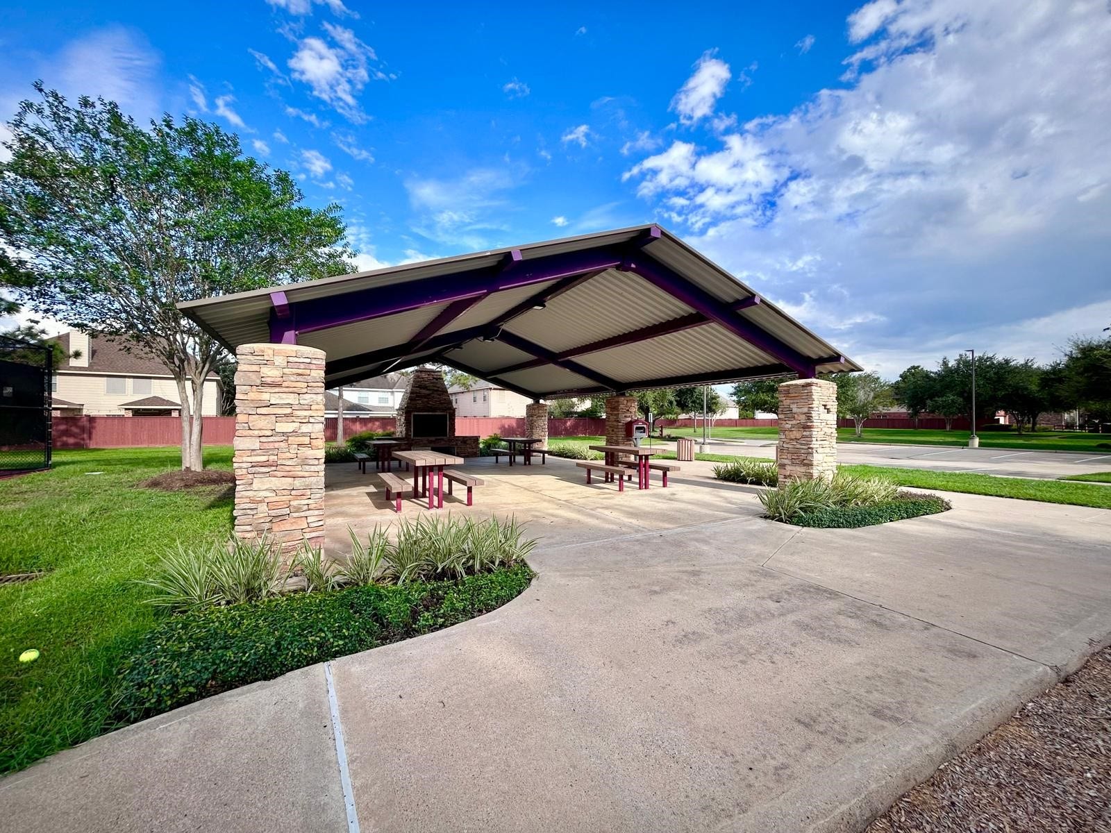 25918 Silver Timbers Lane, Katy, TX 77494 Charming outdoor pavilion with a gabled roof, stone pillars, picnic tables, and a built-in grill, perfect for gatherings and relaxation.