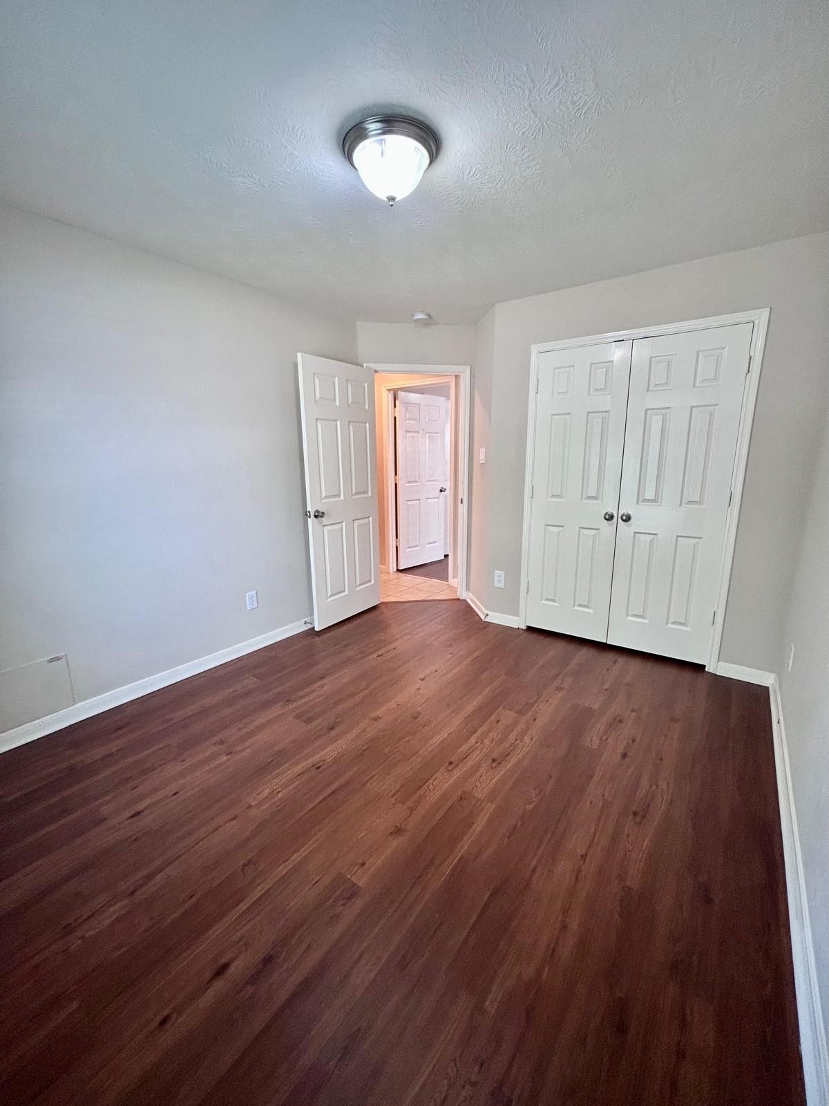 25918 Silver Timbers Lane, Katy, TX 77494 Bright room featuring elegant wood flooring, a spacious closet with double doors, and a modern ceiling light, perfect for a cozy retreat.