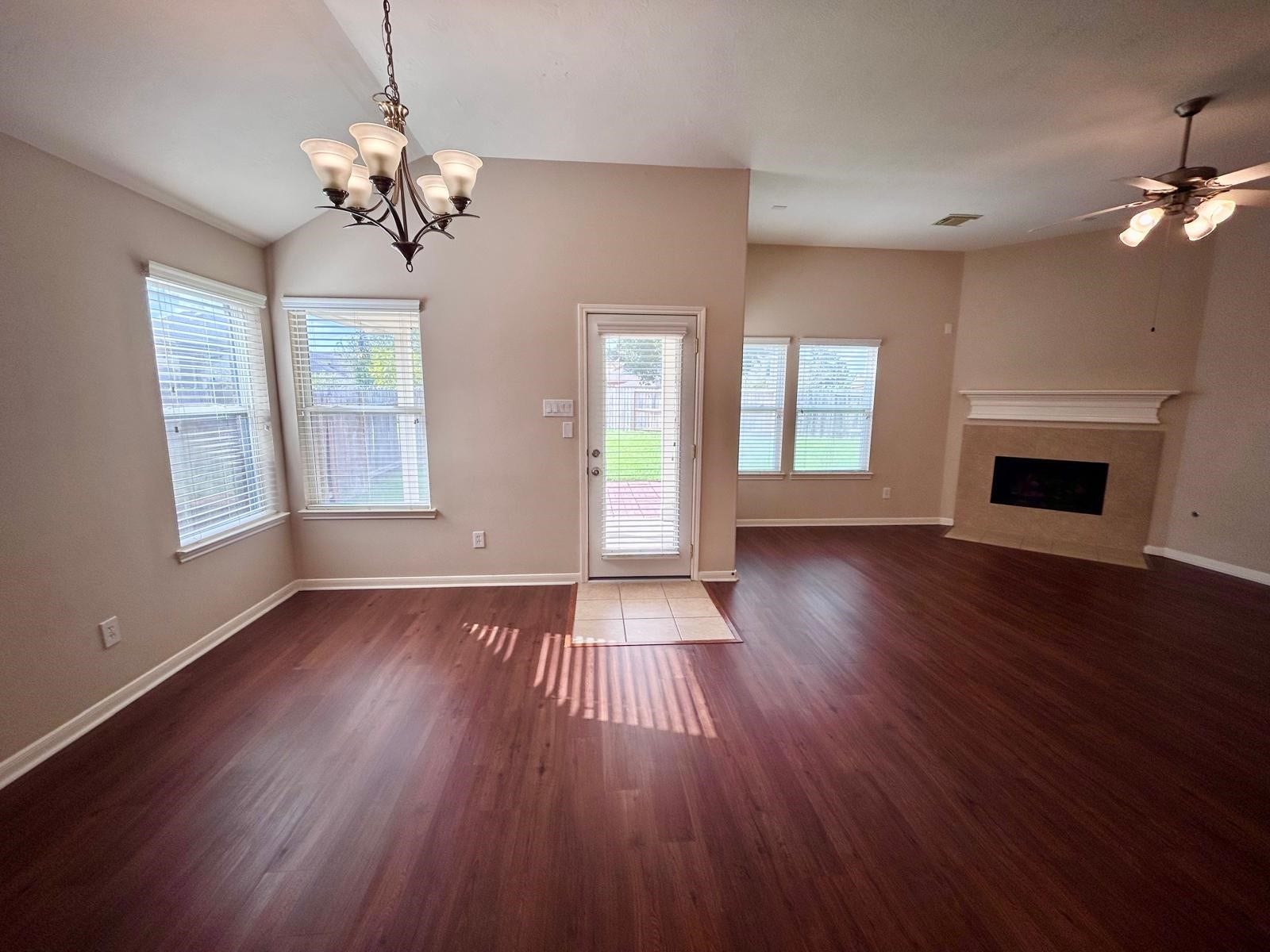 25918 Silver Timbers Lane, Katy, TX 77494 Spacious living area with rich wood floors, abundant natural light from large windows, and a cozy fireplace, perfect for relaxation and entertaining.