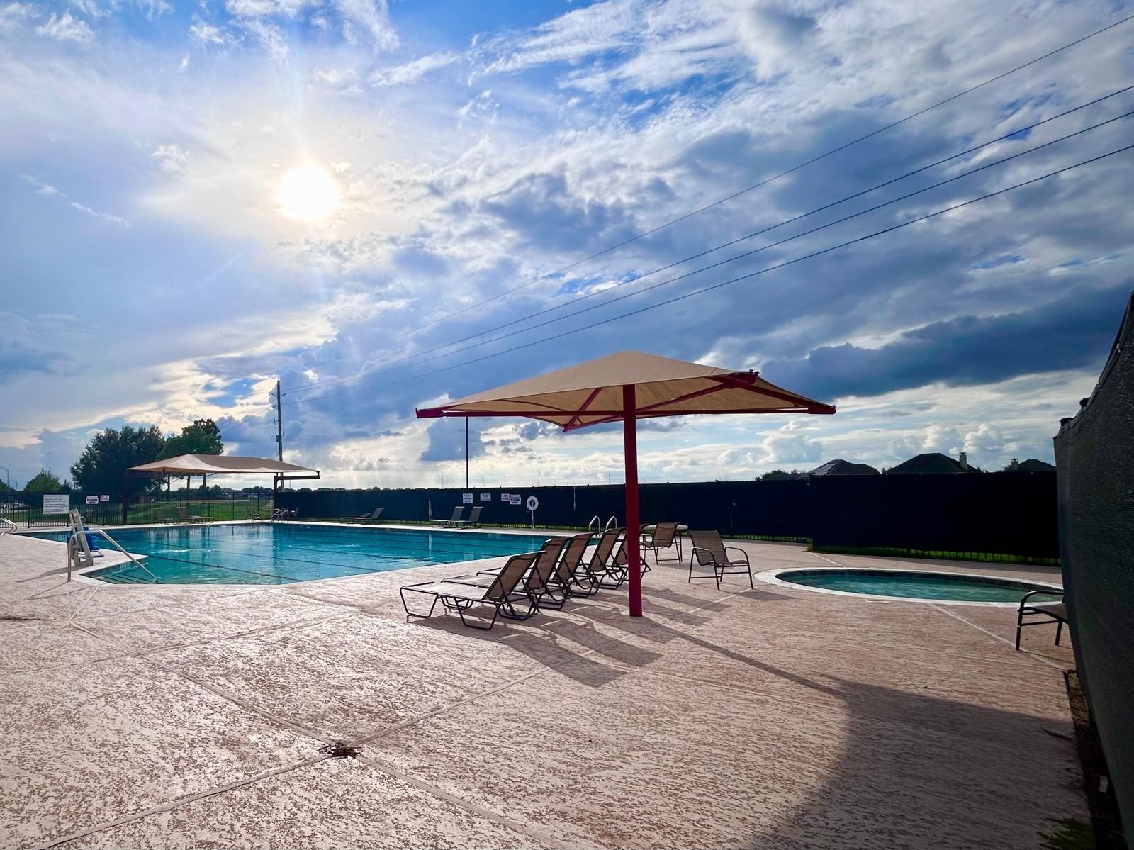 25918 Silver Timbers Lane, Katy, TX 77494 Enjoy sunny days by the expansive outdoor pool, complete with lounge chairs and shaded areas for relaxation.