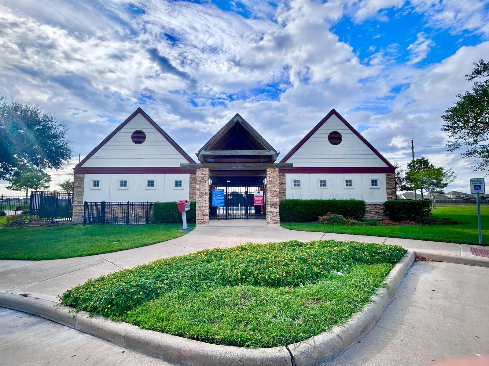 25918 Silver Timbers Lane, Katy, TX 77494 Charming community center with classic gable roofs and stone accents, surrounded by lush greenery and well-maintained gardens.