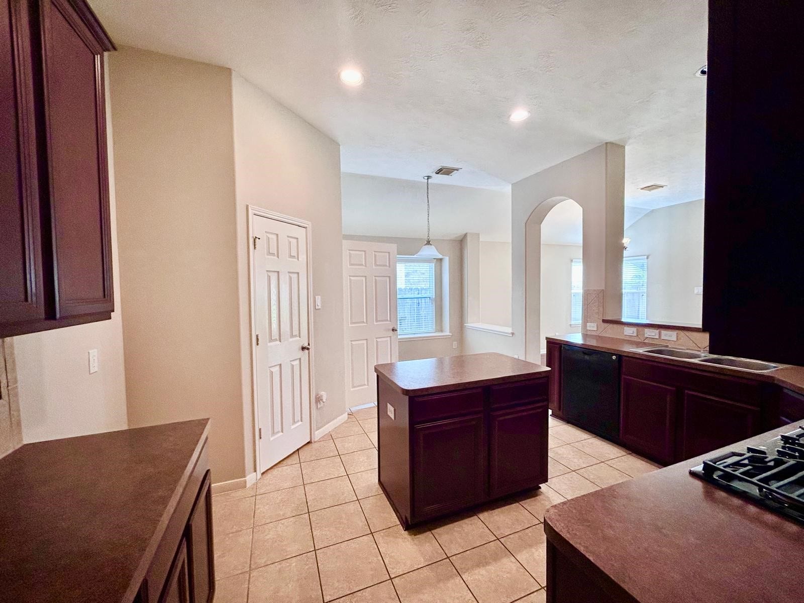 25918 Silver Timbers Lane, Katy, TX 77494 Spacious kitchen featuring dark wood cabinetry, a central island, and ample natural light, perfect for culinary enthusiasts.