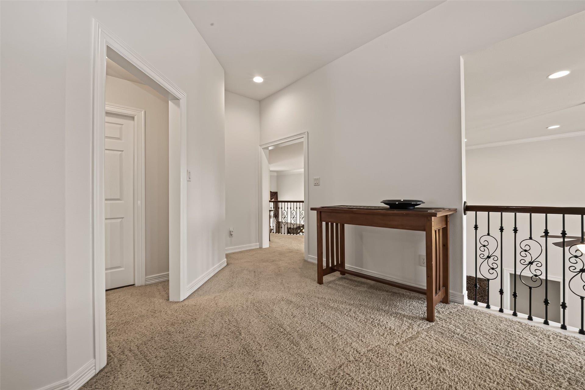 1814 Bartrum Street, Sugar Land, TX 77479 Bright upstairs landing with plush carpeting and elegant railing, providing access to multiple rooms. A stylish console table adds a touch of warmth and functionality.
