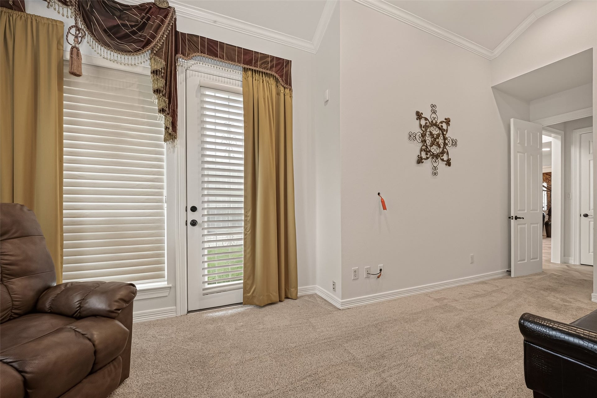 1814 Bartrum Street, Sugar Land, TX 77479 Elegant living area with plush carpet, featuring French doors adorned with stylish drapery, leading to a bright outdoor space.