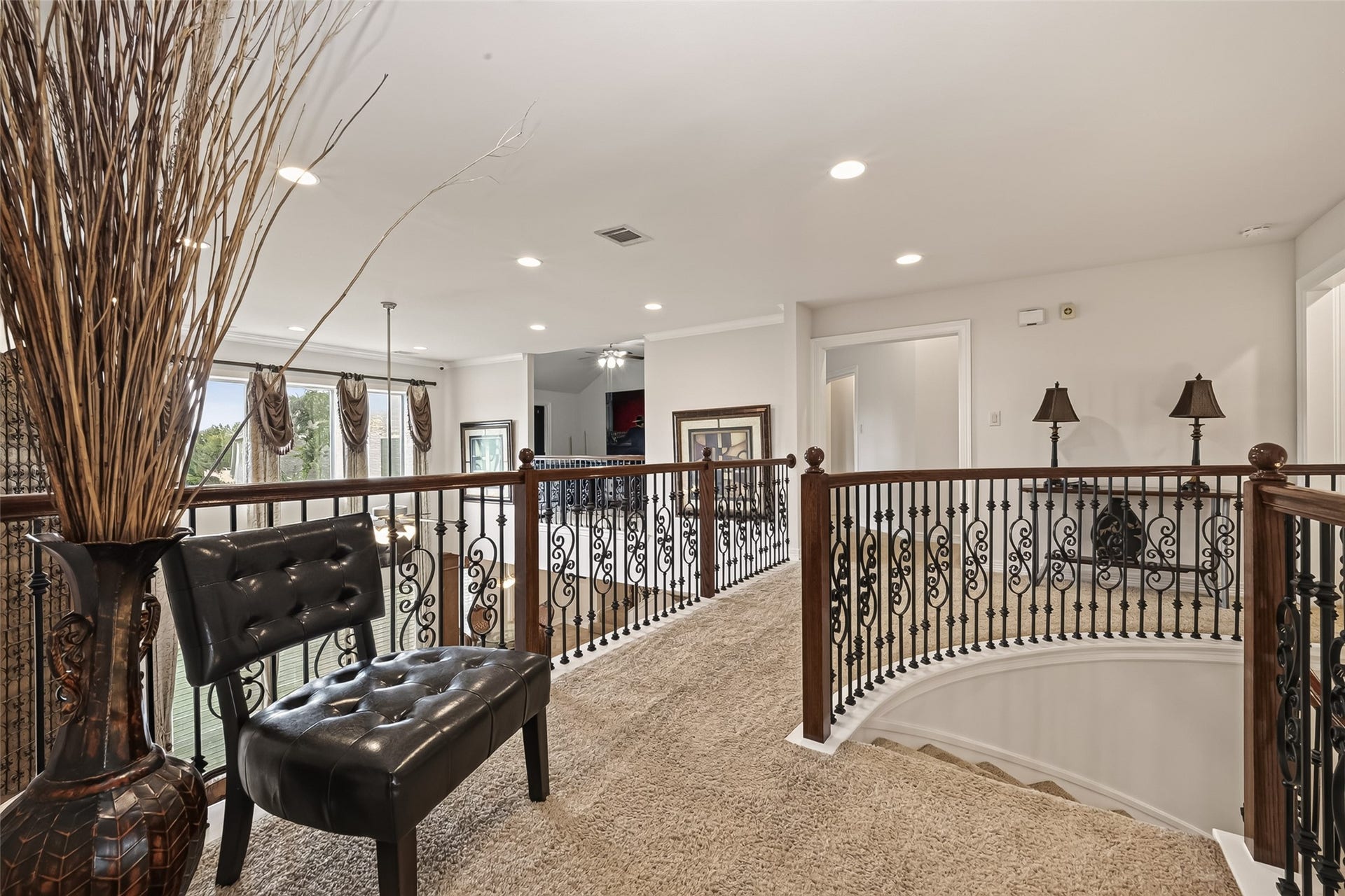 1814 Bartrum Street, Sugar Land, TX 77479 Elegant upper hallway with ornate wrought iron railings, plush carpeting, and abundant natural light.