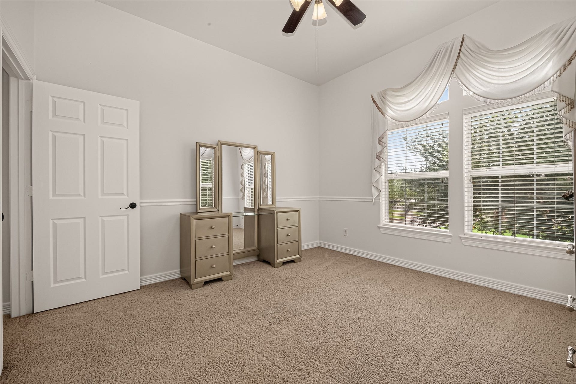 1814 Bartrum Street, Sugar Land, TX 77479 Bright and airy room featuring plush carpeting, a charming vanity, and large windows with elegant drapery for ample natural light.