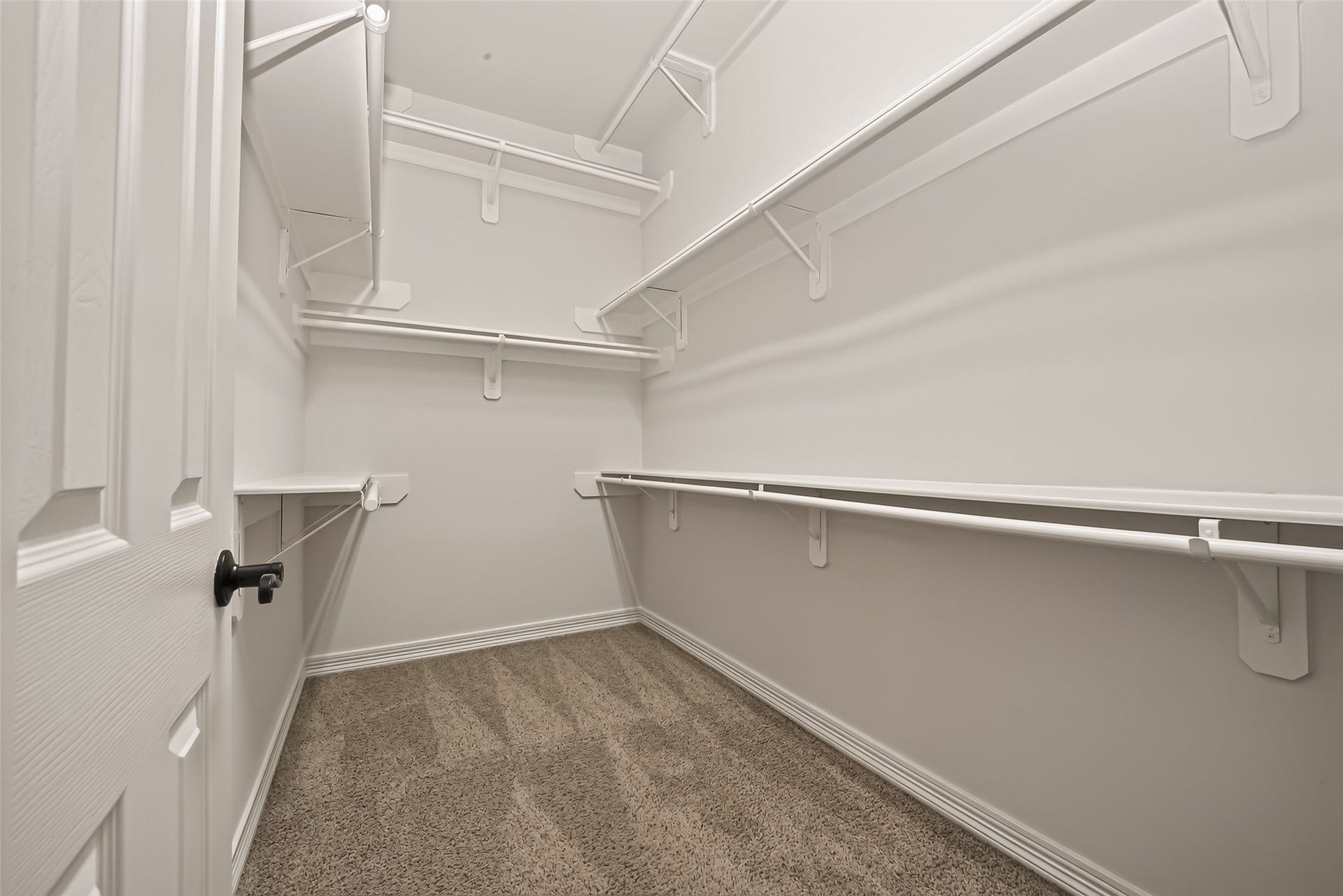 1814 Bartrum Street, Sugar Land, TX 77479 Spacious walk-in closet with ample shelving and hanging space, featuring neutral walls and plush carpeting for a clean, organized look.