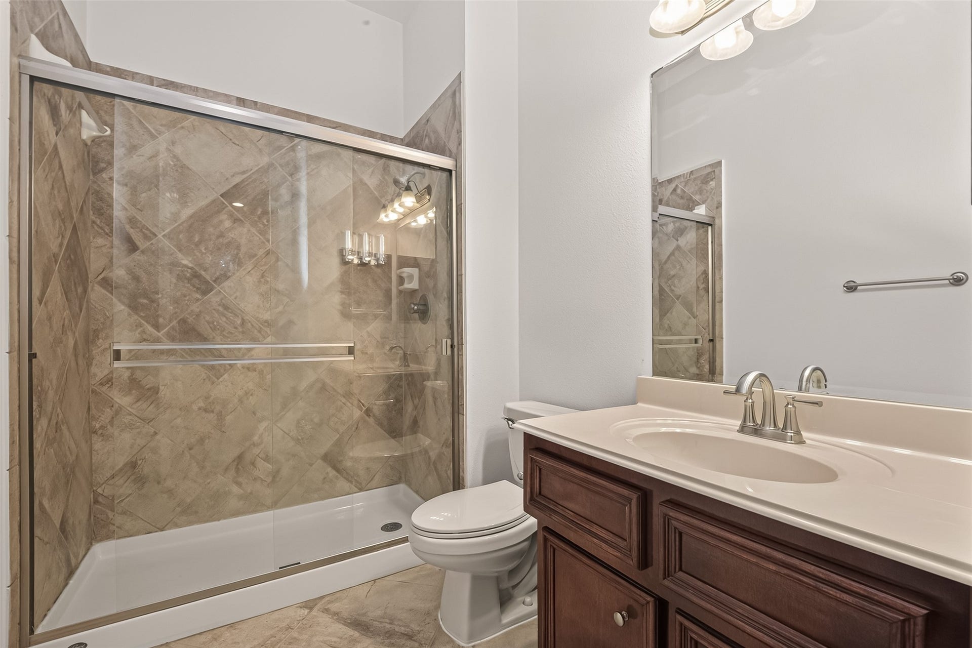 1814 Bartrum Street, Sugar Land, TX 77479 Bathroom featuring a spacious glass-enclosed shower with stylish tilework, complemented by a sleek vanity with a modern sink and polished fixtures.