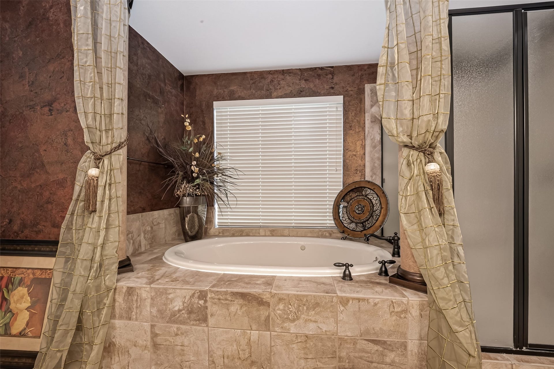 1814 Bartrum Street, Sugar Land, TX 77479 Luxurious bathroom featuring a spacious soaking tub, elegant drapery, and rich textured walls, creating a serene retreat.