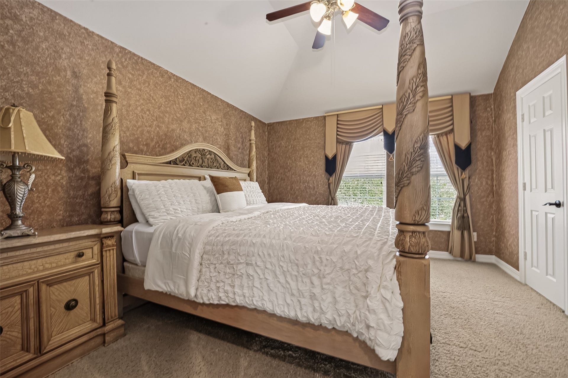 1814 Bartrum Street, Sugar Land, TX 77479 Elegant bedroom featuring a grand four-poster bed, textured walls, and large windows with sophisticated drapery, creating a warm and inviting atmosphere.