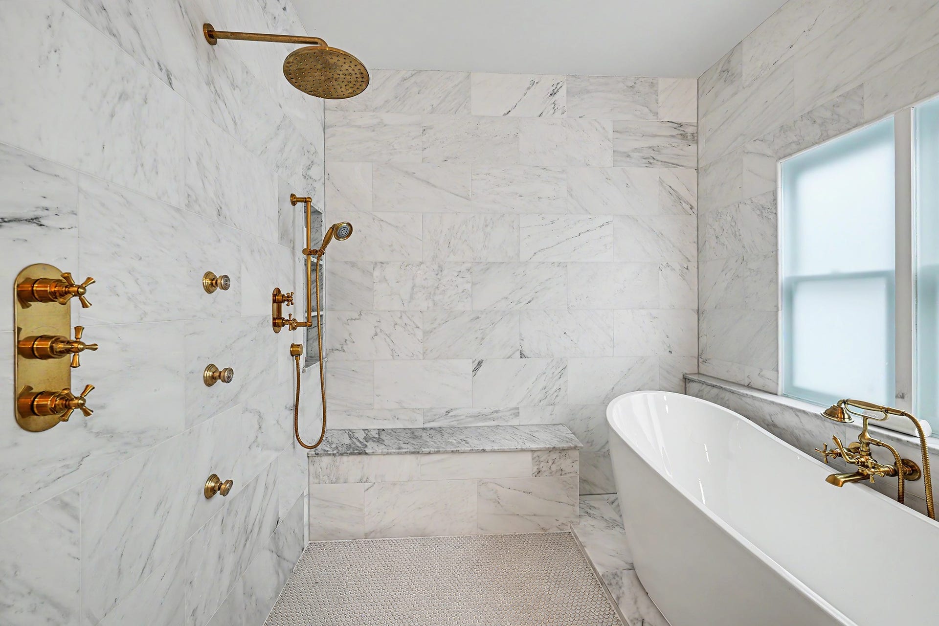 504 W 10th Street, Houston, TX 77008 Shower includes dual showerheads and body sprays. Bench seat in place as well. Freestanding tub with dazzling faucet is surrounded by marble tile.