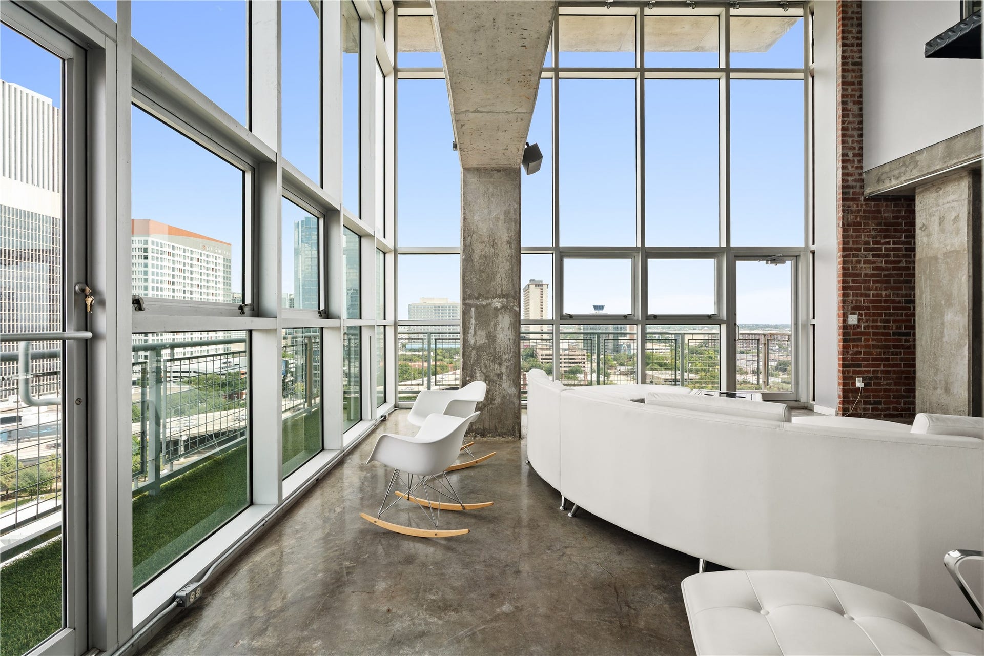 A wrap around private balcony extends directly from the living area, surrounded by soaring glass and offering an open air retreat with elevated city views.