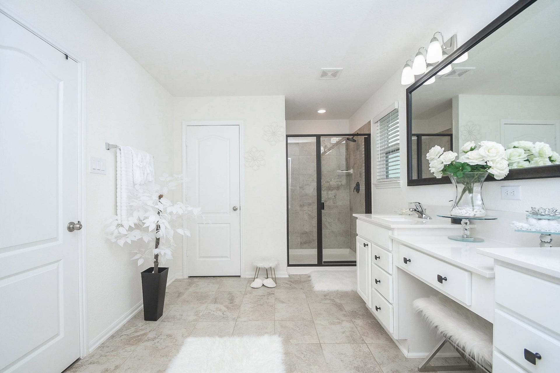 22523 Strathmore Drive, Richmond, TX 77469 This spacious bathroom features a modern design with a large glass-enclosed shower, dual sinks with ample counter space, and elegant decor. Bright and airy with plenty of natural light, it's a perfect blend of functionality and style.