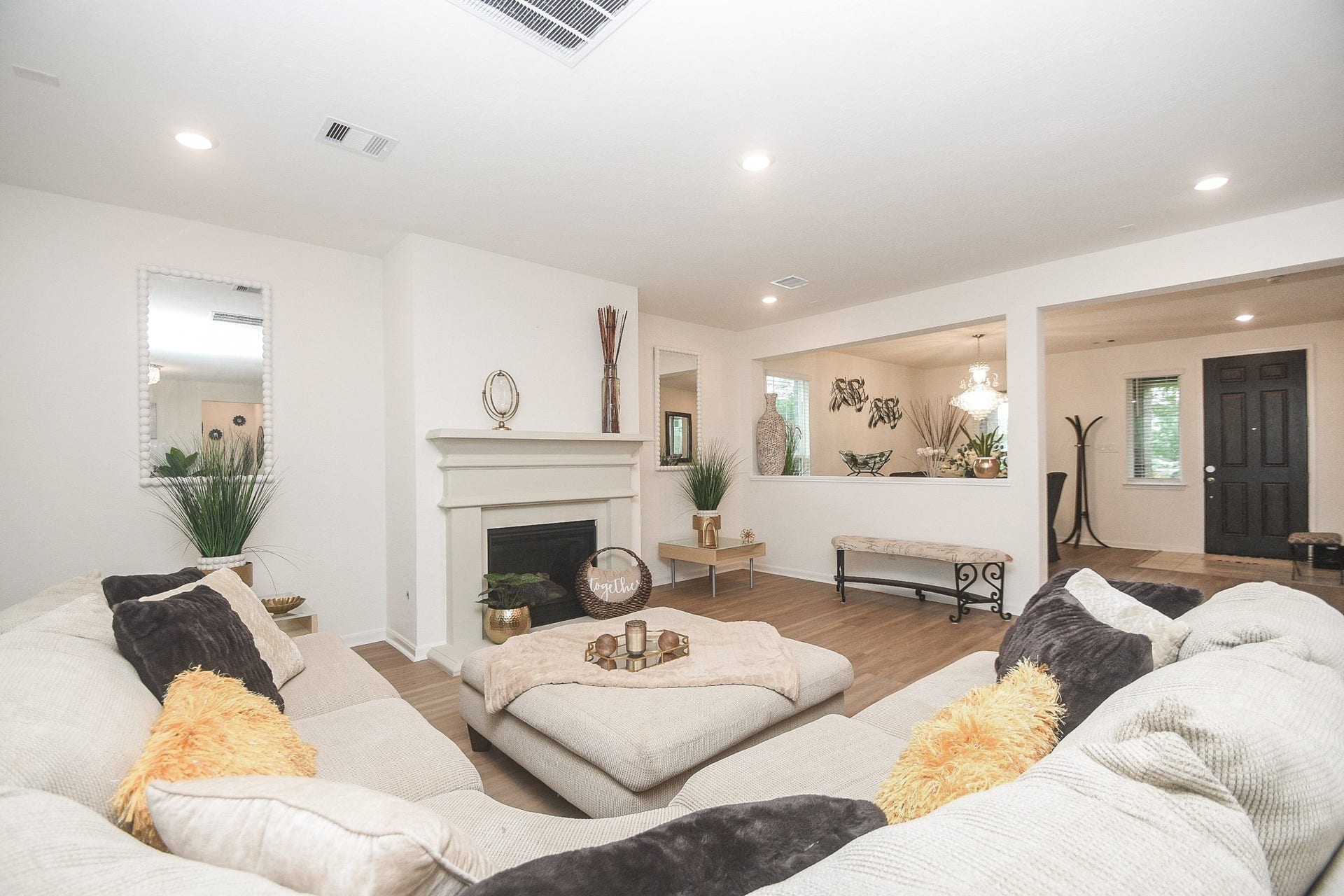 22523 Strathmore Drive, Richmond, TX 77469 This spacious living room features a cozy fireplace, recessed lighting, and a large sectional sofa. These neutral tones and stylish decor layout create a warm, inviting atmosphere.
