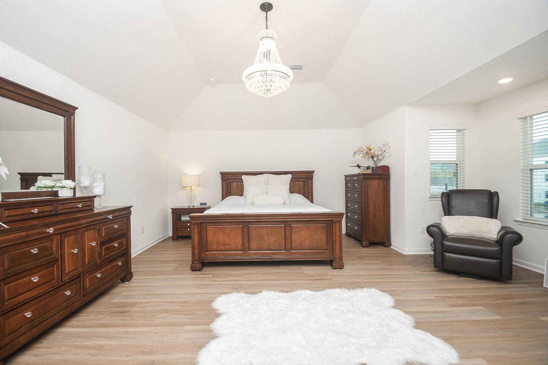 22523 Strathmore Drive, Richmond, TX 77469 This spacious primary bedroom with vaulted ceiling, and a stylish chandelier adds a touch of luxury.