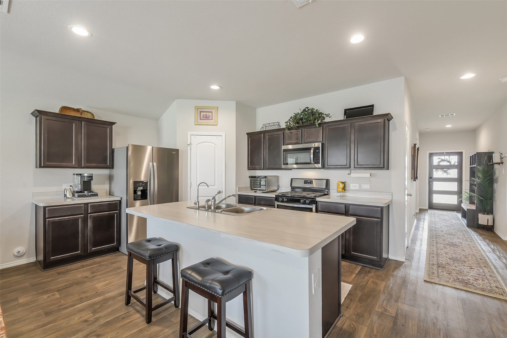 21225 Ivy Woods Court, New Caney, TX 77357 Kitchen with quartz countertops, seating island with a sink, lots of storage and open to the living and dining areas.