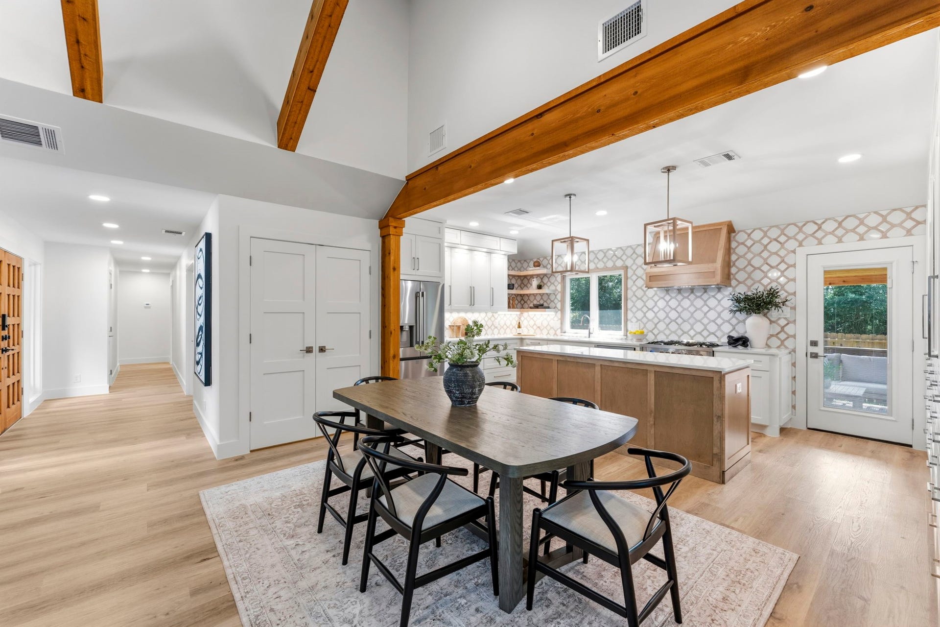 76 Woodhaven Wood Drive, The Woodlands, TX 77380 One of the home's most impressive transformations is the raised kitchen ceiling, beautifully accented with exposed cedar beams that draw the eye upward.
