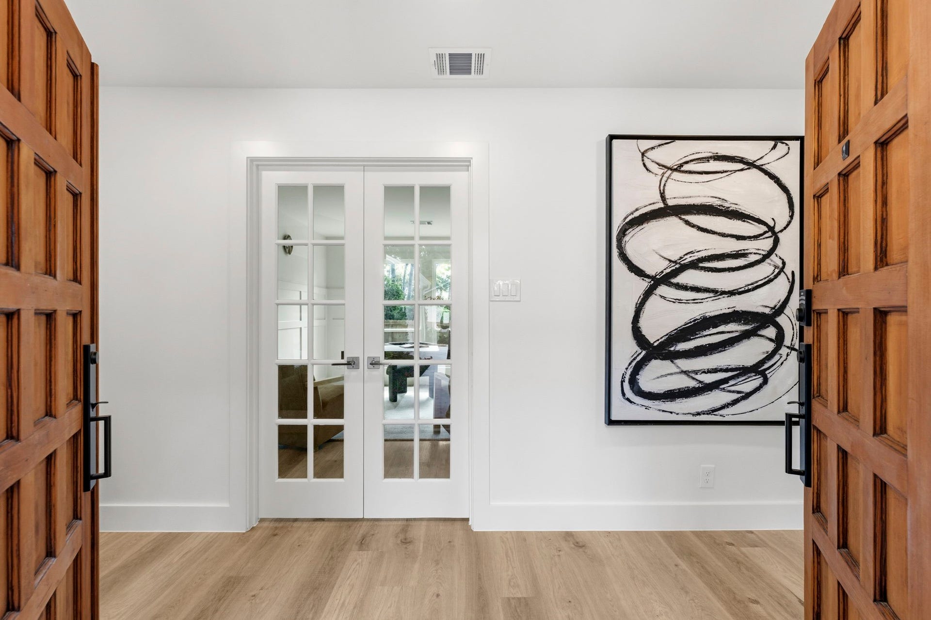 76 Woodhaven Wood Drive, The Woodlands, TX 77380 The welcoming foyer offers a beautiful first impression with warm wood flooring, designer lighting, and thoughtfully curated finishes.