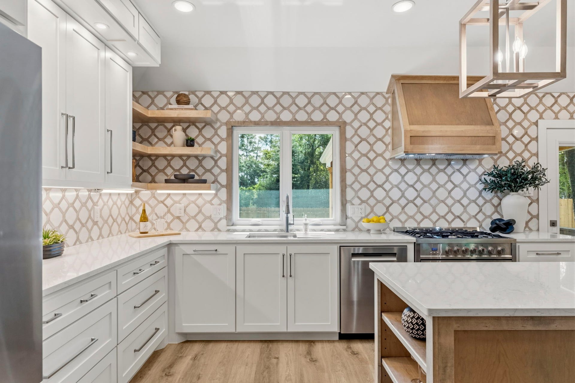 76 Woodhaven Wood Drive, The Woodlands, TX 77380 The handcrafted full-height tile backsplash serves as a stunning focal point, complemented by custom shaker cabinetry with soft-close doors and drawers, under-cabinet lighting, quartz countertops, and warm wood shelving