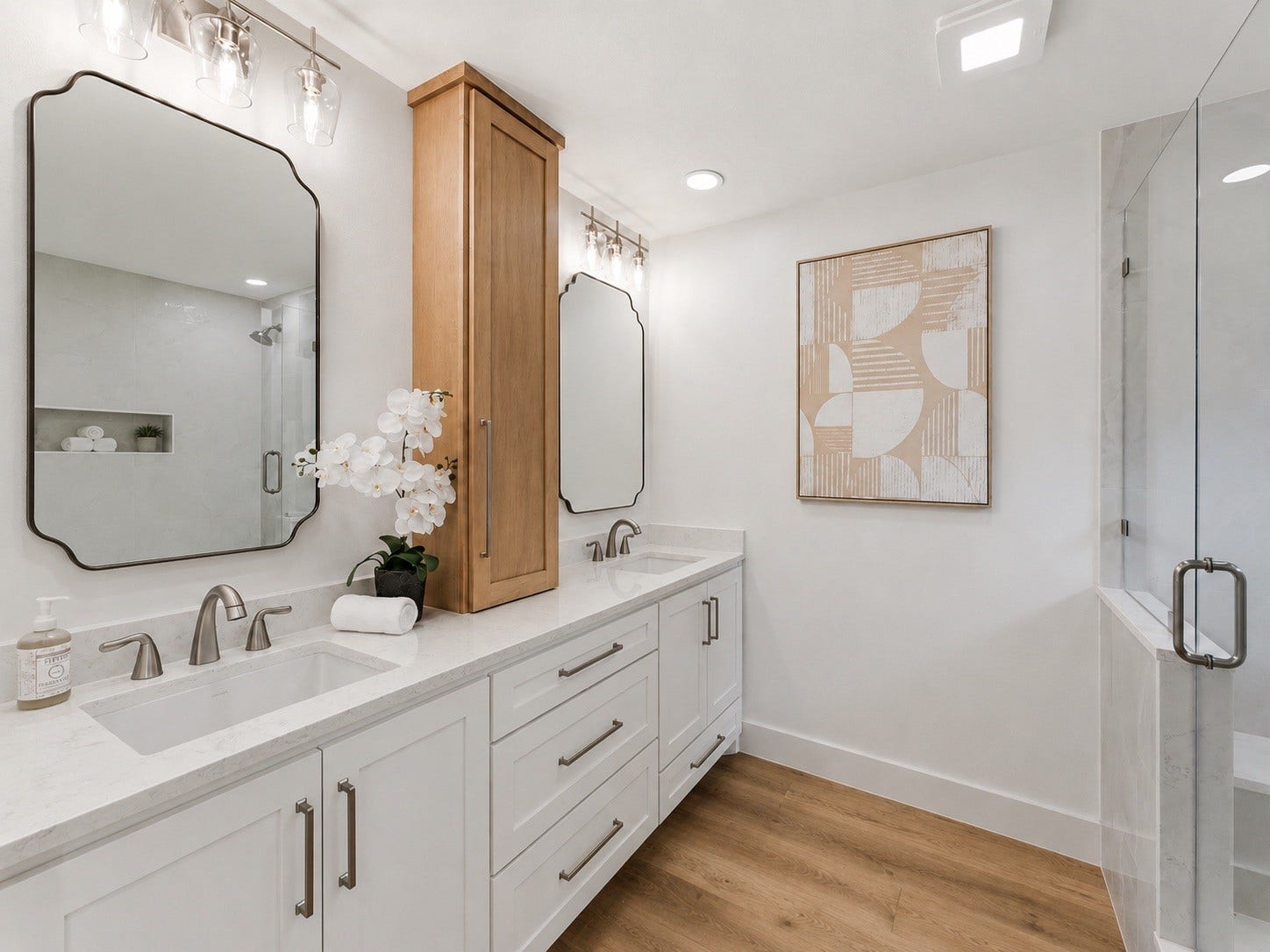 76 Woodhaven Wood Drive, The Woodlands, TX 77380 The spa-inspired primary bath with dual quartz vanities, custom cabinetry, designer mirrors, and elegant lighting.