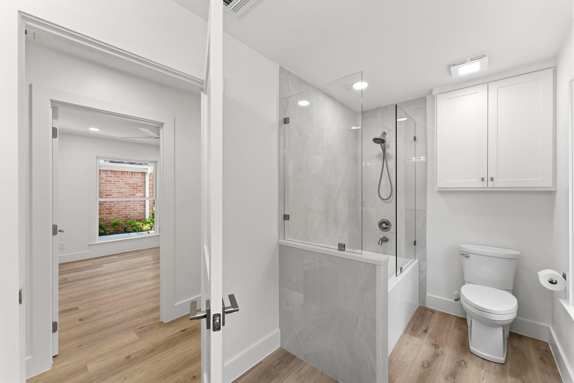 76 Woodhaven Wood Drive, The Woodlands, TX 77380 Upgraded bathroom features a tiled tub and shower combination and is conveniently located adjacent to the secondary bedrooms.