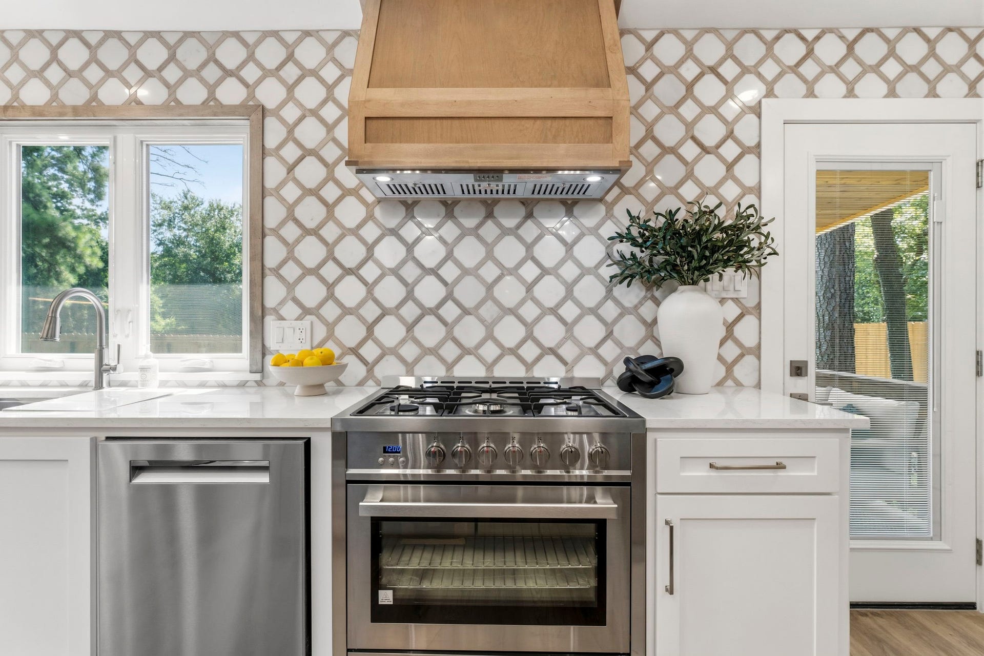 76 Woodhaven Wood Drive, The Woodlands, TX 77380 Designed with the home chef in mind, this stunning kitchen showcases a premium suite of high-end stainless steel appliances, including a professional-style range beneath a custom wood vent hood.