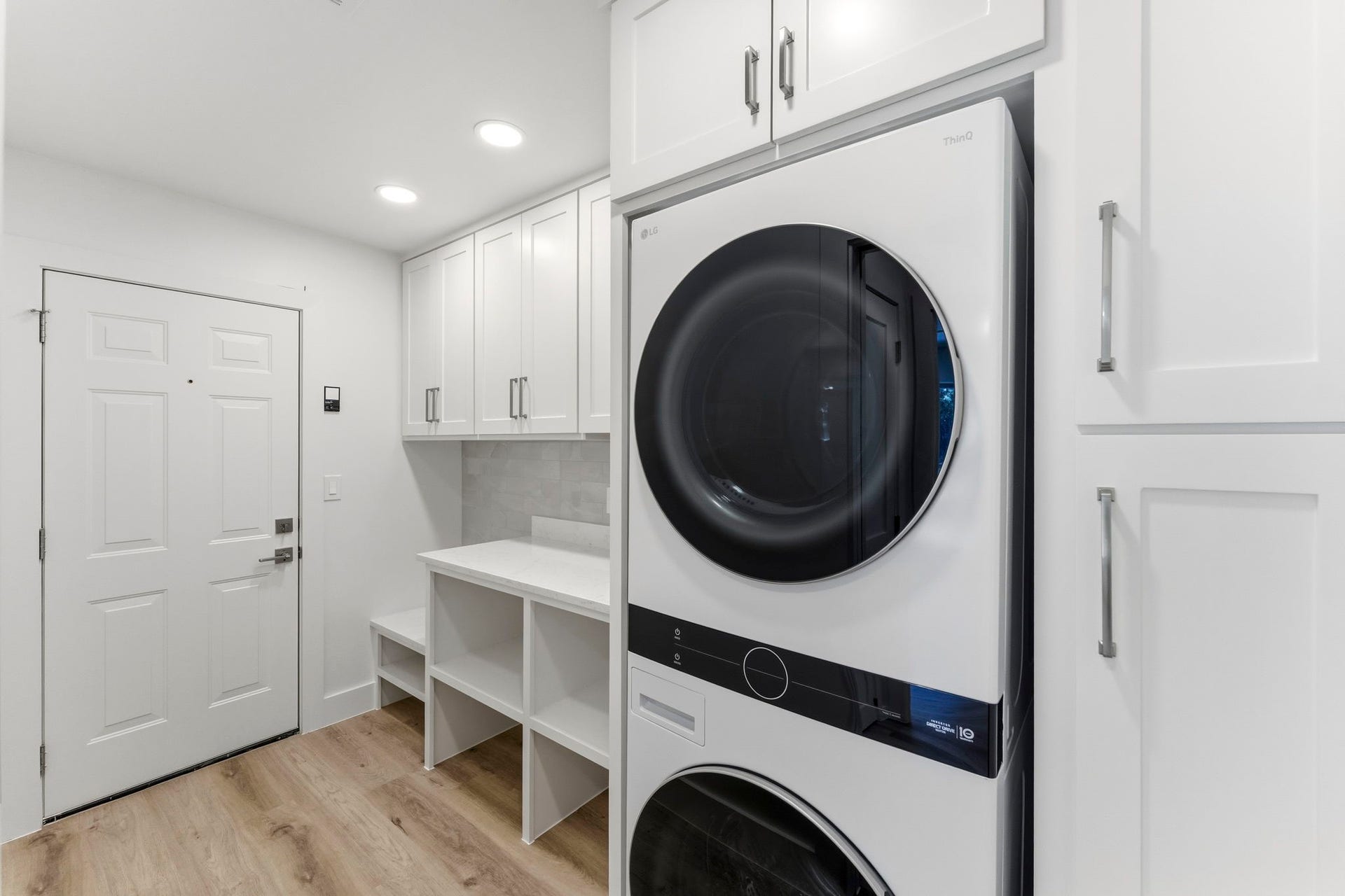 76 Woodhaven Wood Drive, The Woodlands, TX 77380 Amazing laundry room with included stackable washer and dryer, custom built-ins, open shelving, and folding space.